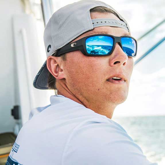 Man wearing Costa Fantail Pro Polarized Sunglasses with matte black frame and blue glass lens.