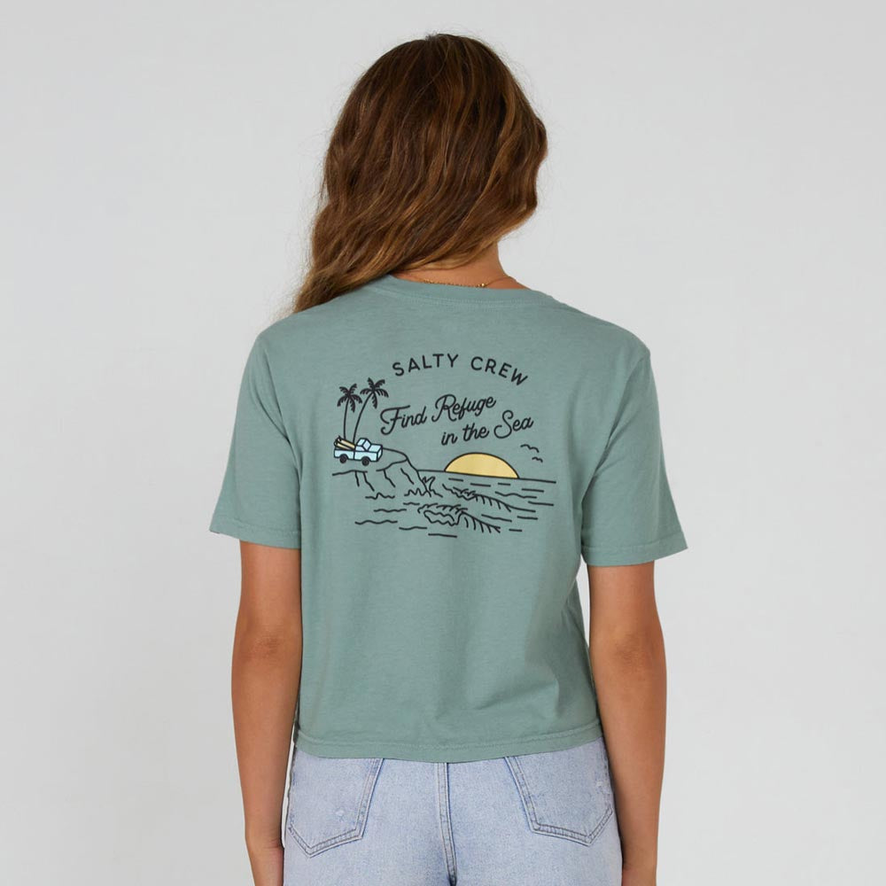 Girl wearing a sage Salty Crew Lookout Women's Crop T-Shirt with sunset scene